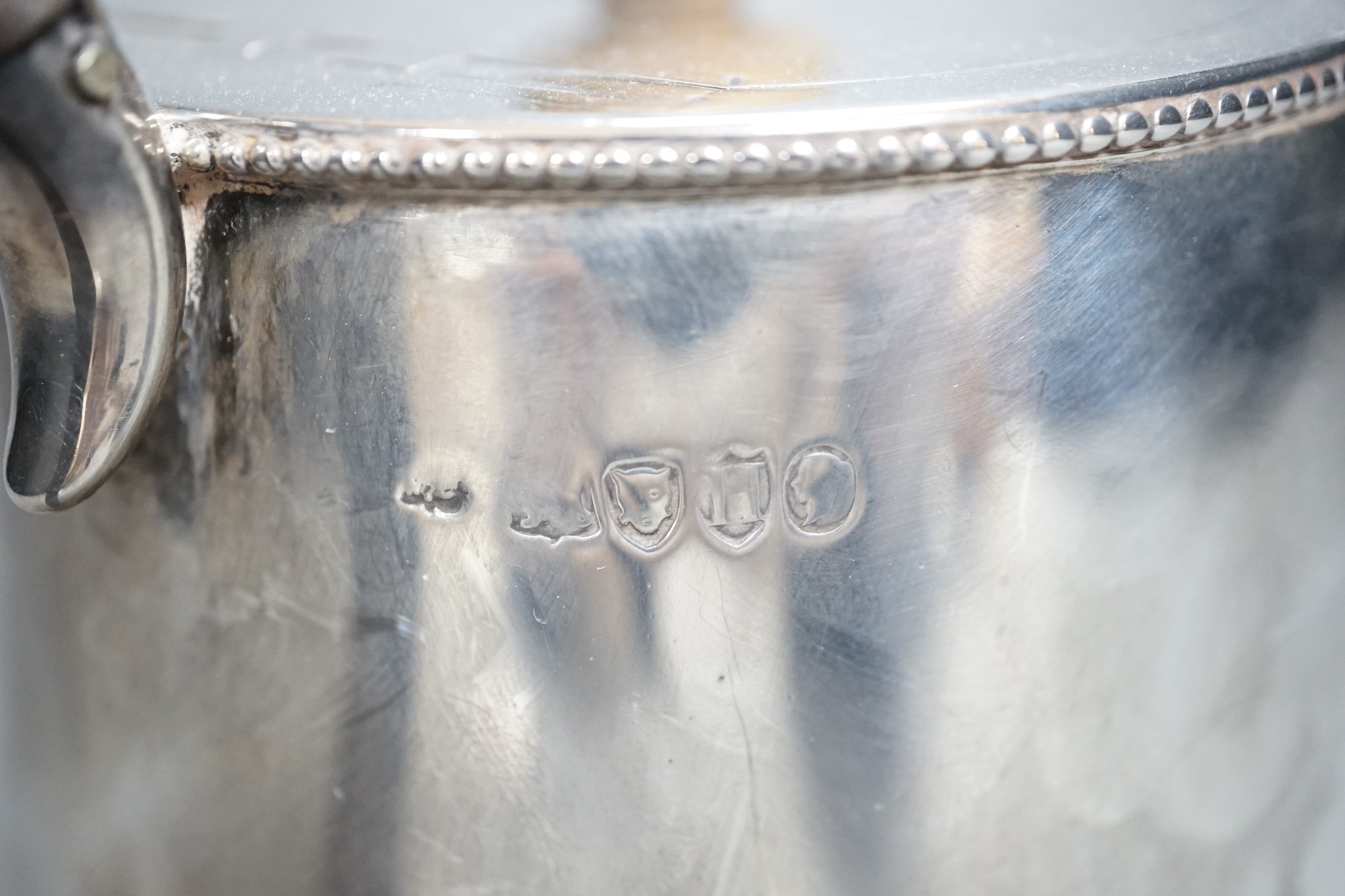 A late Victorian silver teapot, of cylindrical tapering form, William Comyns, London, 1883, gross 15oz.